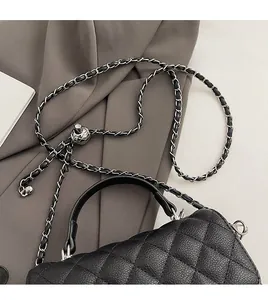 Detail of silver chain strap with ball adjuster and quilted texture on black bag