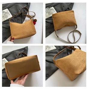 Detailansichten der braunen Wildledertasche mit glattem Lederboden und Bommel-Anhänger