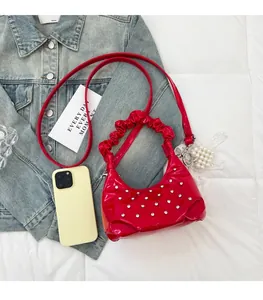Macro view of red patent leather cloud bag with crystal polka dots and ruched handle