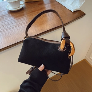 Close-up of black matte suede Boston bag with brown leather handles and gold metal rings