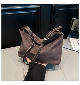 Close-up of dark brown suede hobo bag with adjustable strap and minimalist metal buckle