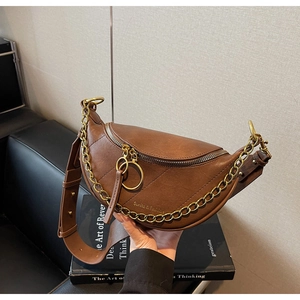 Dettaglio borsa a sella marrone con motivo litchi, catena oro e logo Sunita & Fashion