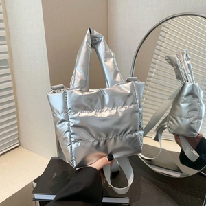 Metallic silver quilted puff handbag with top handle and adjustable shoulder strap