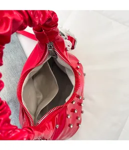 Top view of red patent leather cloud bag featuring silver zipper and inner compartment
