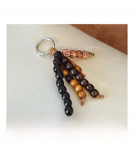 Detail view of retro beaded keychain with wooden beads and silver metal ring on marble