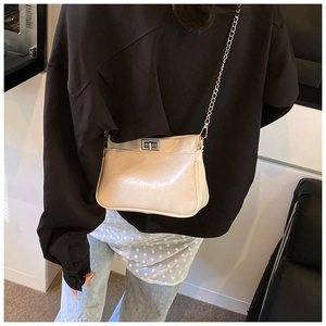 Dettaglio borsa a tracolla beige crema con chiusura a scatto argento e tracolla a catena