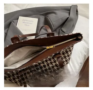 Detail of premium houndstooth tote bag showing smooth golden zipper and lining