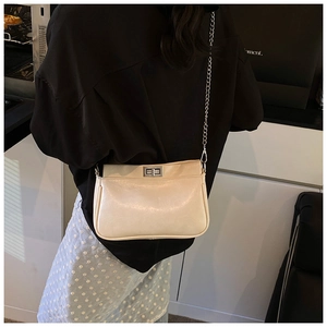 Dettaglio della borsa squadrata in pelle PU bianco avorio con fibbia e catena argento