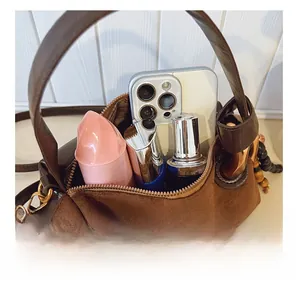 Interior view of brown suede crossbody bag showing capacity for phone and cosmetics