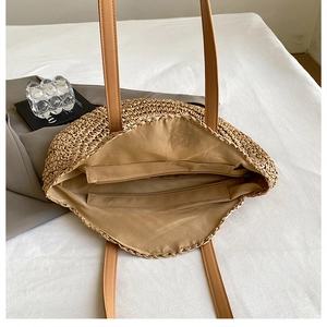 Top view of woven straw bag showing inner khaki lining and zippered pocket detail