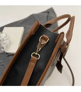 Close-up of golden metal hardware and black lychee grain leather on a handbag