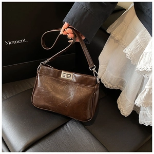 Dettaglio borsa a mano marrone vintage con chiusura girevole rettangolare in argento