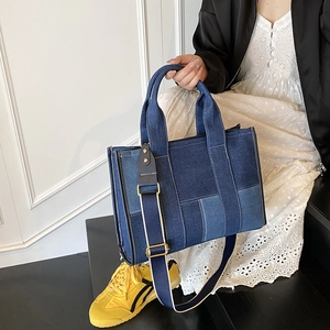 Detail of blue denim patchwork tote bag with detachable strap in a casual lifestyle setting
