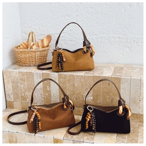Three matte Boston bags in brown and black on stone steps with French lifestyle props