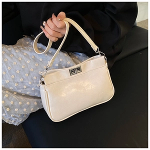 Dettaglio della chiusura a scatto argento e della trama in pelle sintetica beige della borsa