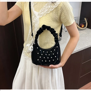 Detail of black pleated cloud bag with rhinestones and pearl bow pendant decoration