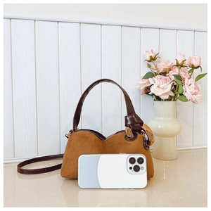 Detailed view of brown frosted Boston bag size compared to a smartphone with metal rings