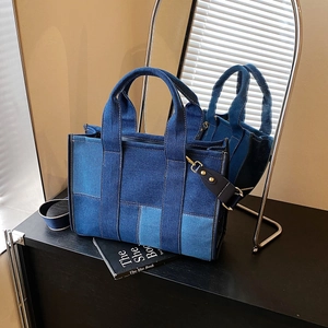 Detail of color-blocked denim tote bag with dual handles and detachable shoulder strap