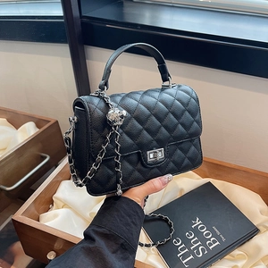 Classic black quilted crossbody bag with top handle and metal chain strap in high texture