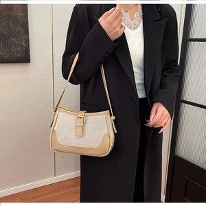 Detail view of contrast color canvas underarm bag with retro leather trim and buckle