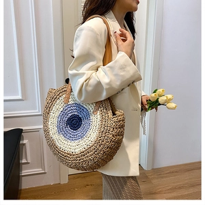 Detailed close-up of a circular woven shoulder bag with concentric straw pattern design