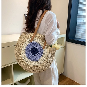 Detailed view of woven straw shoulder bag with colorful concentric patterns