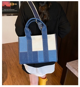 Detail of color-block denim tote bag showing mixed blue patchwork and sturdy handles