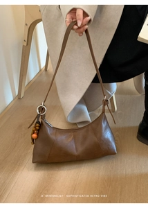 Détails du sac croissant vintage marron avec perles en bois et texture cuir huilé