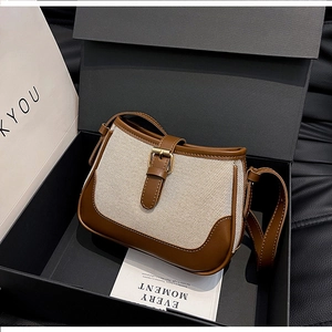 Canvas and leather patchwork crossbody bag presented in a premium black gift box with a card