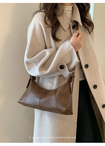 Détail du sac bandoulière en cuir mat marron foncé avec coutures fines et boucle argent