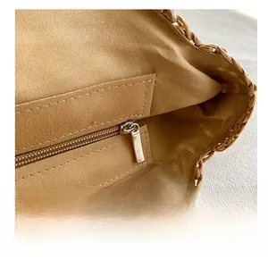 Macro shot of smooth metal zipper and inner fabric lining of the straw shoulder bag