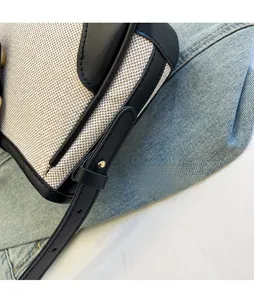 Detail of adjustable leather strap with silver studs on canvas and leather shoulder bag