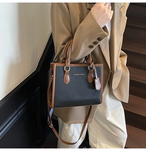 Close-up of stylish contrast handbag with gold hardware and textured leather finish