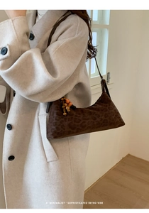 Détail d'un sac à bandoulière léopard marron foncé avec perles décoratives