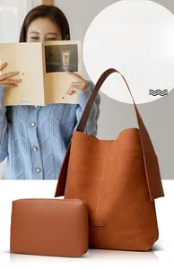 Macro detail of large brown suede tote bag featuring a matching zipper pouch and wide strap
