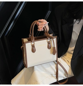 Close-up of beige lychee texture tote bag with brown trim and gold hardware