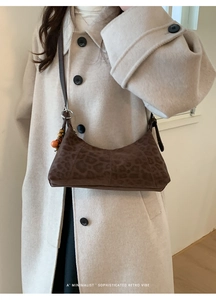 Détail du sac croissant rétro à motif léopard avec perles et esthétique minimaliste