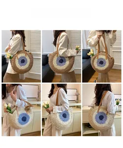 Detail view of round straw shoulder bag with evil eye pattern and leather straps