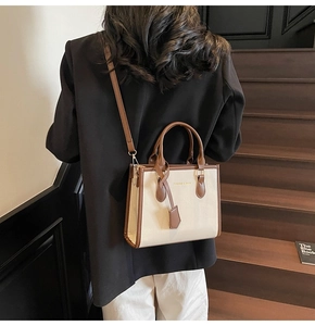 Modern white and brown tote bag styled on a staircase for a sophisticated fashion look