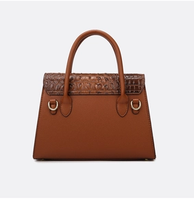 Détail d'un sac à main marron avec rabat en crocodile et texture cuir de litchi