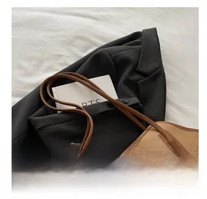 Close-up of brown litchi pattern leather tote with silver metal buckle detail
