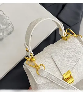 Detail of white litchi pattern leather bag with golden metal twist lock and texture