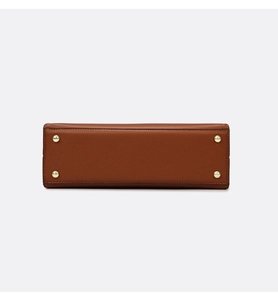 Vue détaillée du fond de sac en cuir avec quatre pieds de protection en métal doré