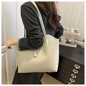 Close-up of light green lychee textured leather tote with metallic square buckle detail