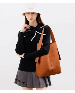 Detail of caramel brown matte suede tote bag showing texture and wide shoulder strap