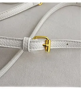 Detailed macro view of white lychee pattern leather strap with golden metal buckle