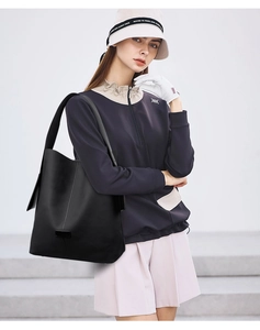 Outdoor lifestyle view of a black large hobo shoulder bag with matte leather finish