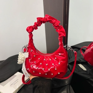 Red rhinestone ruched hobo bag with pearl and lace bow charms shown in a lifestyle view