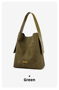 Detail view of large dark green suede tote bag with smooth leather strap stitching