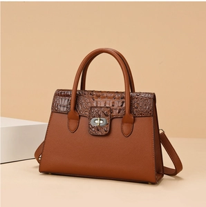 Détail du sac à main marron avec rabat texture crocodile et fermoir rotatif doré